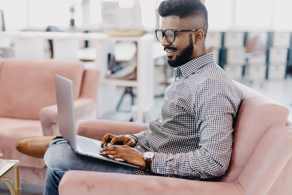 Casual,Young,Man,Using,Laptop,With,Happy,On,Sofa,In
