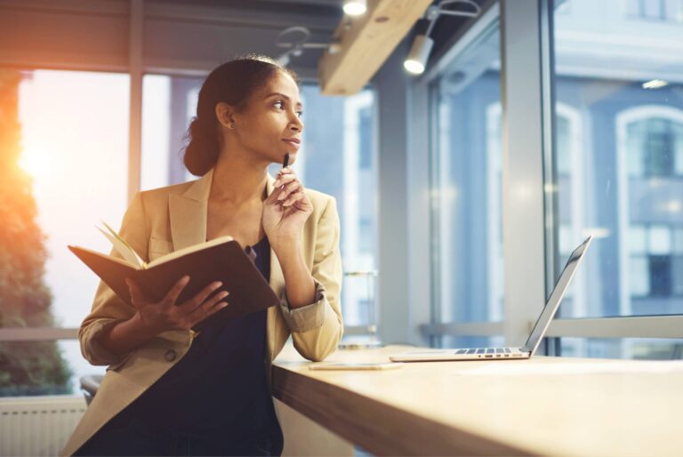 Elegant,Young,Woman,Looking,Away,Thoughtfully,While,Holding,Notepad,And
