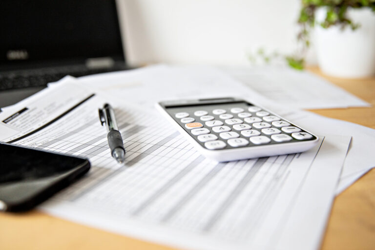 Calculator,And,Pen,With,Papers,At,Office,Desk