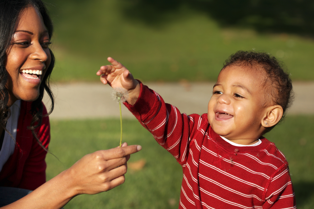 Mother,And,Son,Playing,With,A,Dandelion,In,The,Park